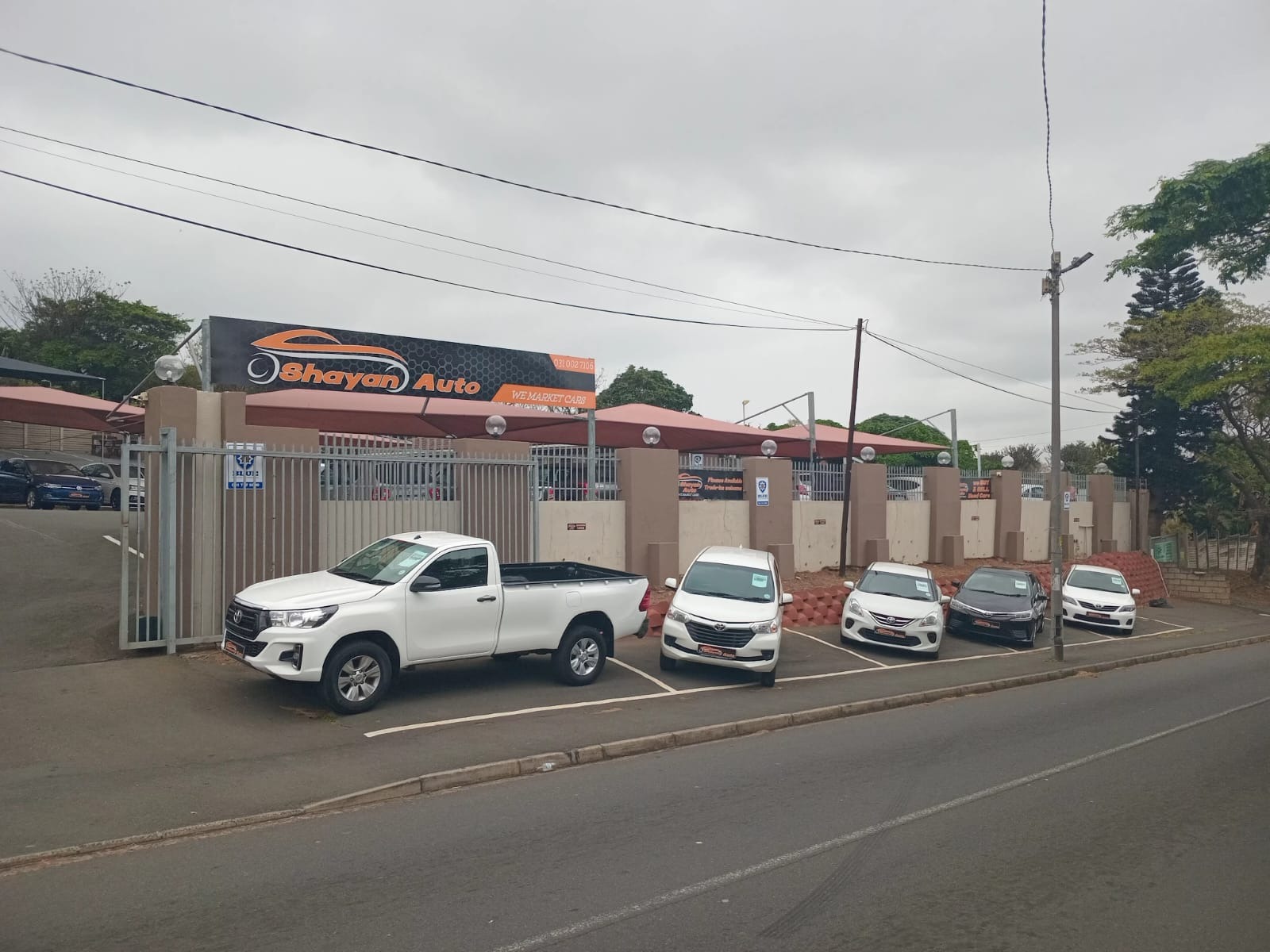 A brightly lit car dealership showroom showcasing a diverse selection of new and used cars. Include elegant sedans, rugged SUVs, and sporty hatchbacks, all neatly arranged. Highlight colorful banners featuring special offers and a welcoming atmosphere.